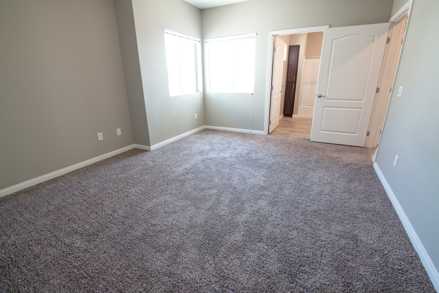 He is a before interior photograph showcasing a room lit by a combination of daylight, indoor lighting, and the view from the two windows. While typical photography struggles to balance these light sources, we can bring it all together in perfect balance.