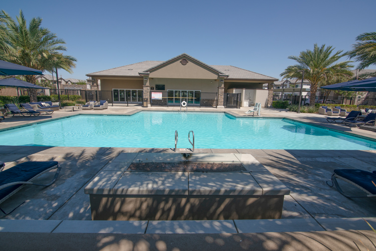 This before photo captures an appealing scene, featuring a relaxing fireside ambiance and an inviting pool, suggesting it's a perfect day for a swim.