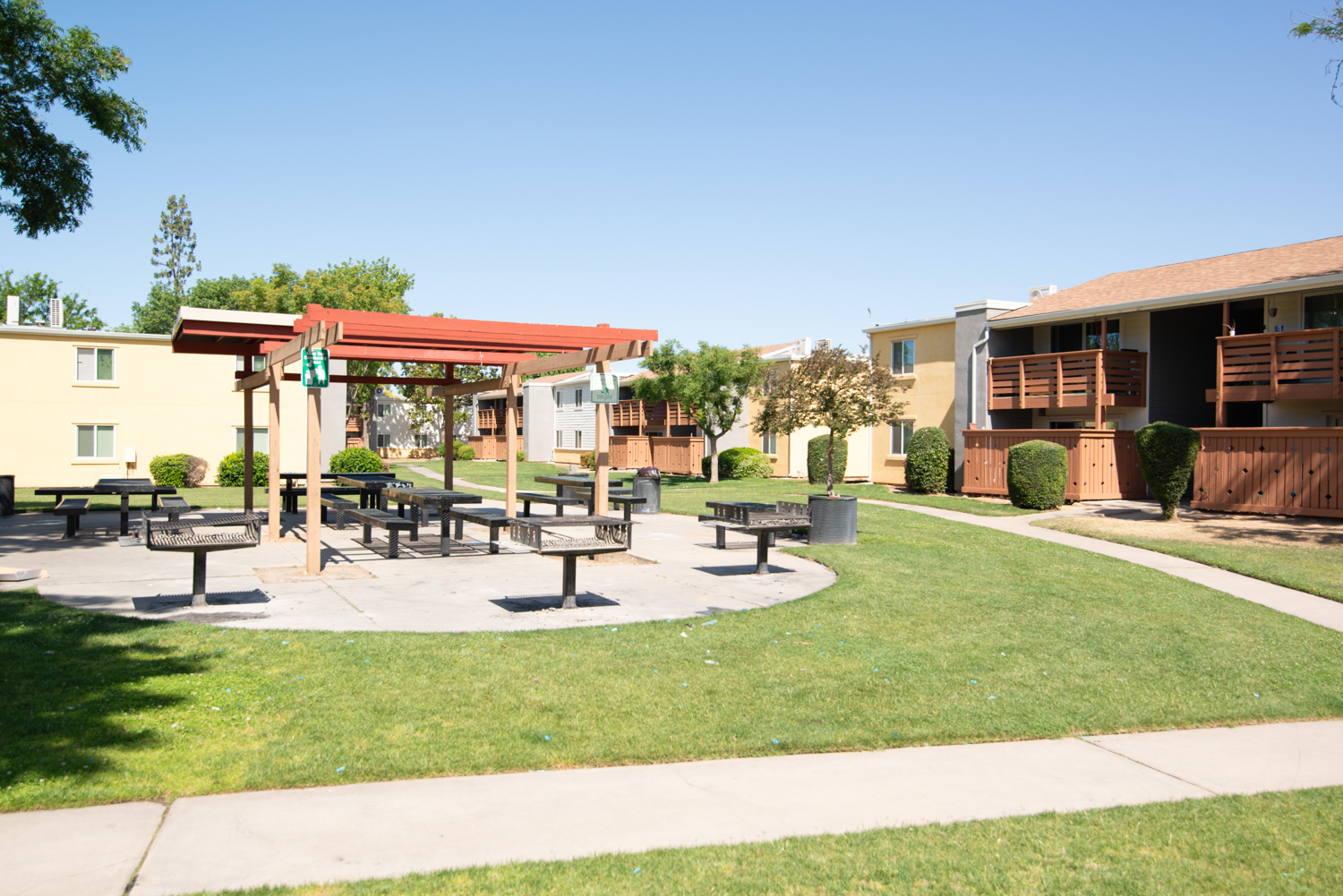 A before image of an apartment that is not in pristine condition, illustrating common issues such as trash on the ground, dirty sidewalks, and a faded sky, reflecting both large and small problems typical in many communities.