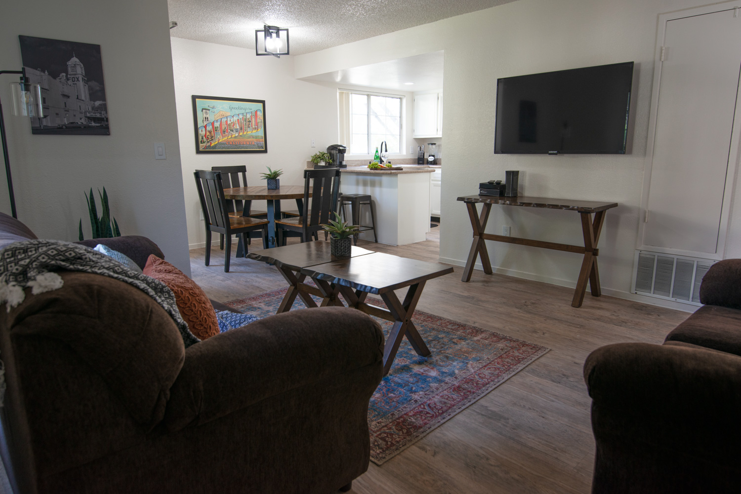 A before photograph of an interior apartment space, characterized by noticeable shadows and yellow and magenta hues. The window in the background is overexposed, appearing blown out and white.